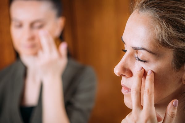 Deux femmes pratiquant l’EFT en tapotant des points d’acupression sur le visage pour libérer les émotions et réduire le stress à Aix-en-Provence.